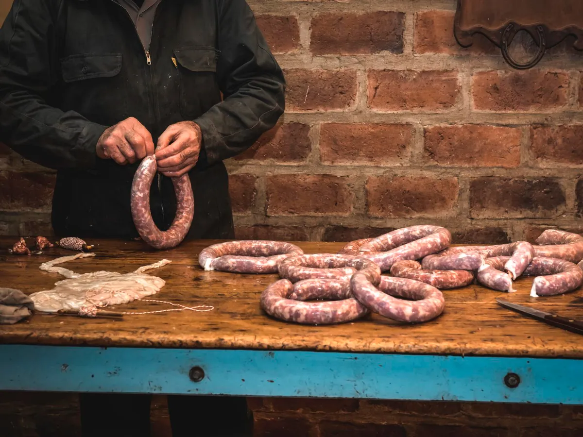 Persoană care pregătește cârnații - Foto: Freepik (Imagine cu rol ilustrativ)