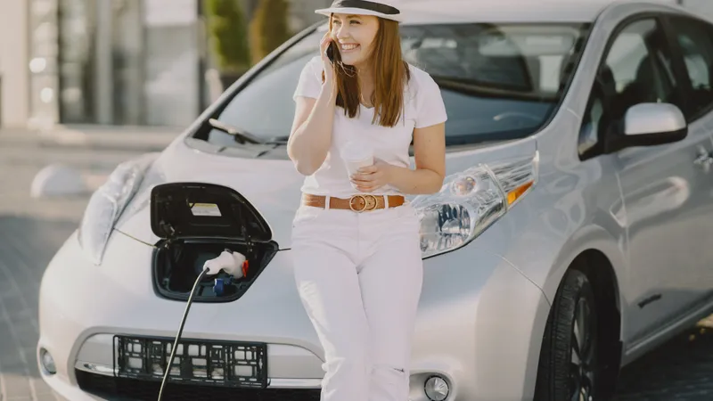 Femeie așteptând mașina electrică la încărcat - Foto: Freepik