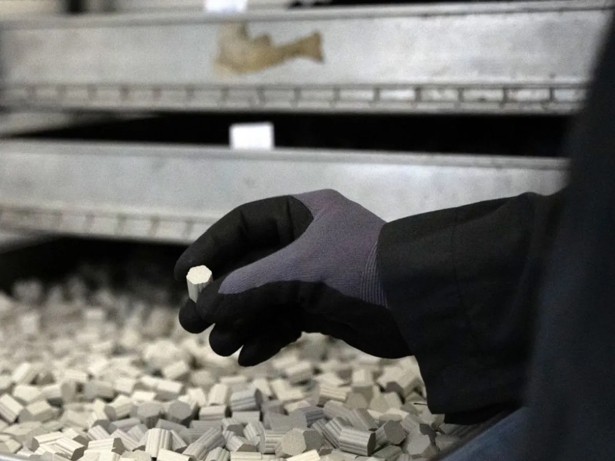 Un angajat scoate o bucată de pulbere propulsivă presată, la uzina Nitrochemie Aschau GmbH - Foto: Profimedia Images
