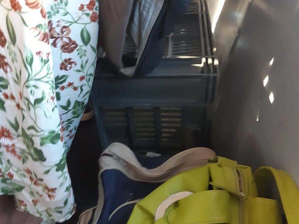Călători stând pe o ladă, scaunul improvizat, după ce au fost nevoiți să se suie în singurul tren care circula. Foto: Newsweek Romania