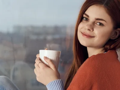Femeie frumoasă care bea cafea dimineața - Foto: Freepik