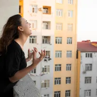 femeie la balconul unui apartament - Foto: Magnific (rol ilustrativ)