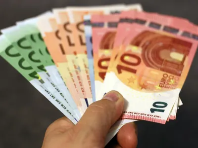 Bărbat ţinând în mână un evantai făcut din bancnote euro - Foto: Pexels/Pixabay