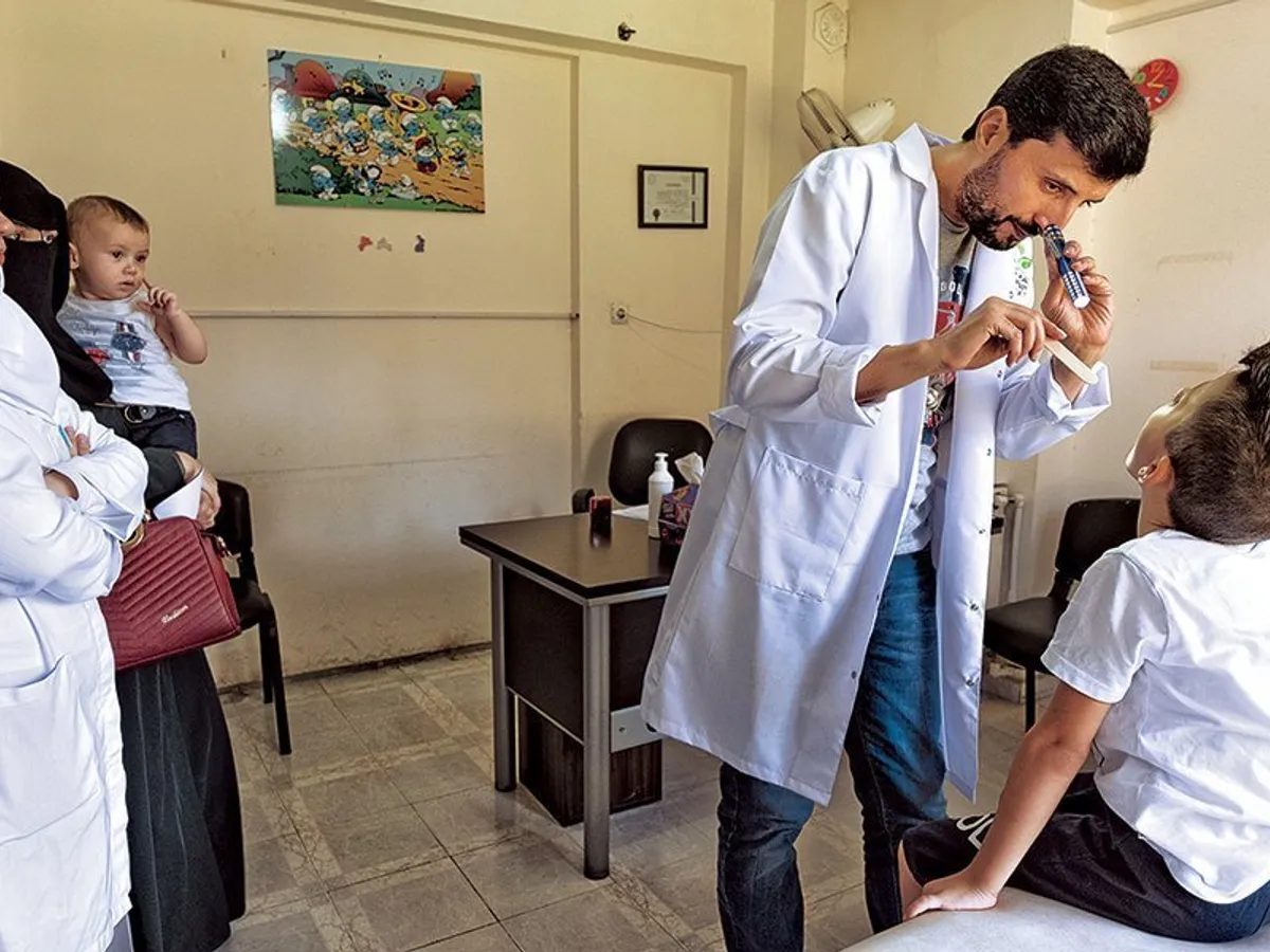 PILULA AMARĂ. O reţea de medici sirieni lucrează cu grupurile nonguvernamentale de ajutor, în încercarea de a le oferi refugiaţilor îngrijiri de bază. Jouma examinează un pacient în Antakya