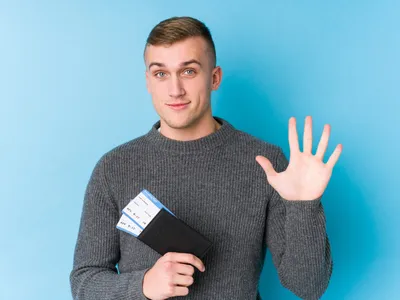 Bărbat care ține un pașaport în mână - Foto: Freepik (Imagine cu rol ilustrativ)