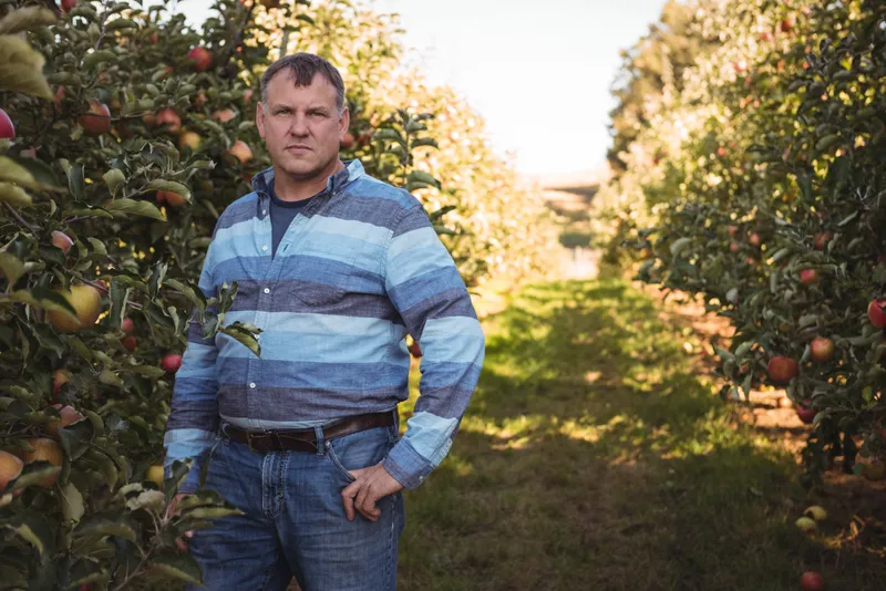 Portretul unui fermier &icirc;n picioare &icirc;ntr-o livadă de meri - Foto: Magnific.com (Imagine cu rol ilustrativ)