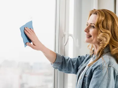 Femeie care șterge geamul - Foto: Freepik (rol ilustrativ)