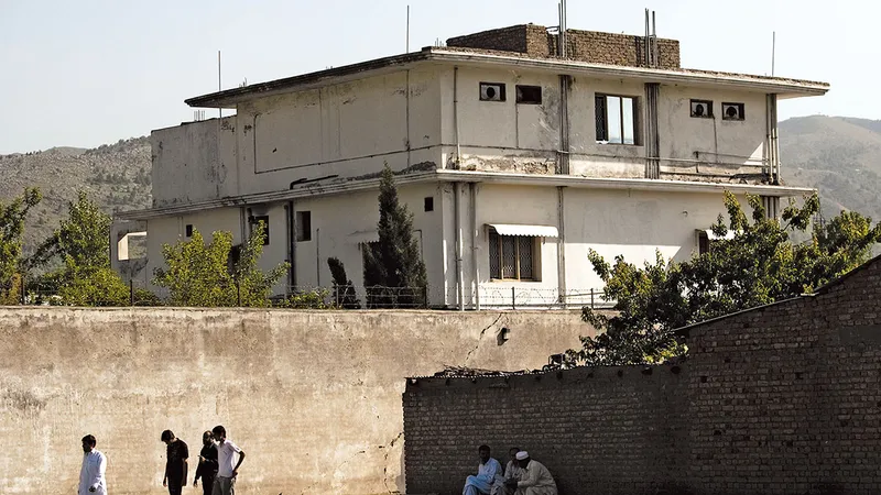 Oamenii trec pe lângă complexul unde a fost ucis bin Laden pe 2 mai 2011, la aproape un deceniu după evenimentele din 11 septembrie