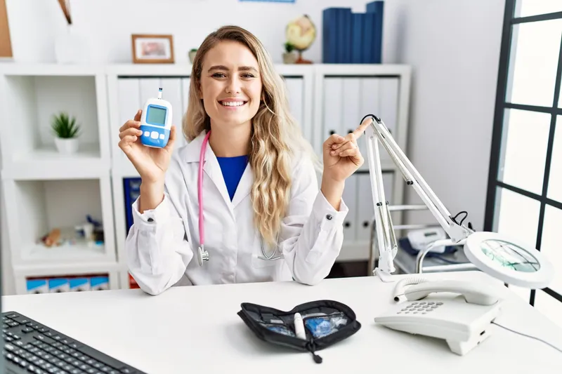 Doctoriță țin&acirc;nd un glucometru - Foto: Magnific.com (Imagine cu rol ilustrativ)