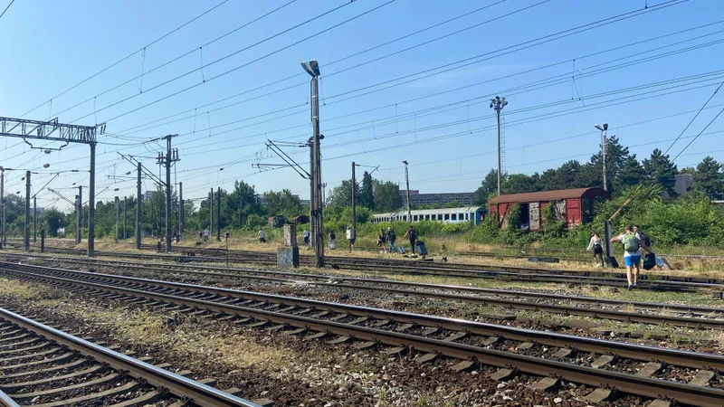 Pasagerii care au luat-o la pas cu bagajele printre șine, în drum spre Gara de Nord, la 30 de grade - Foto: Observator News