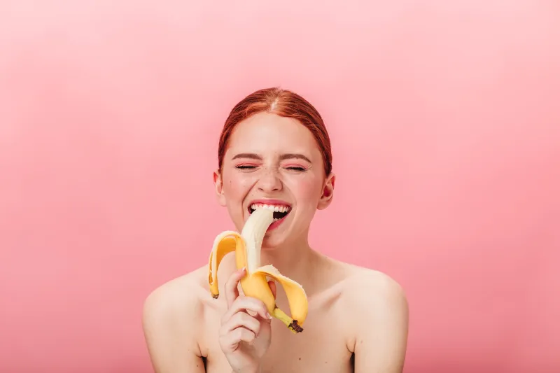 Femeie care măn&acirc;ncă o banană - Foto: Freepik (Imagine cu rol ilustrativ)