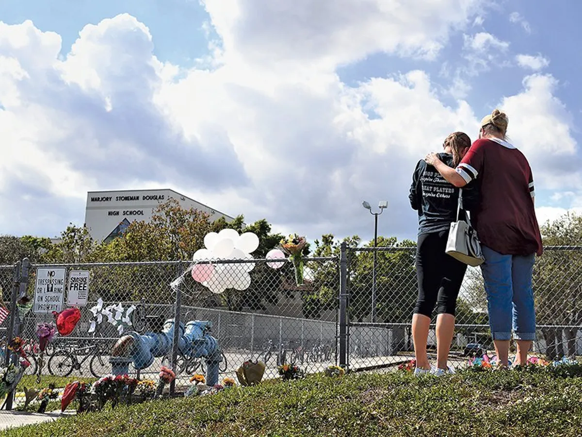 Mama și fiica se îmbrățișează lângă liceul Marjory Stoneman Douglas