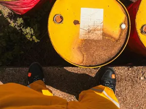 Butoaie cu petrol lângă o persoană care stă în picioare - Foto: Pexels/Biong Abdalla