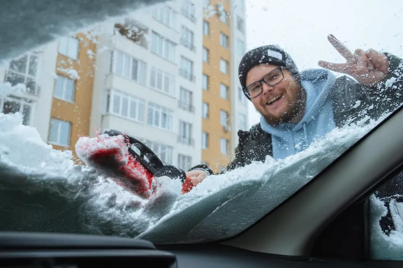 Bărbat care dezgheață geamul și curăță zăpada - Foto: Freepik (Imagine cu rol ilustrativ)