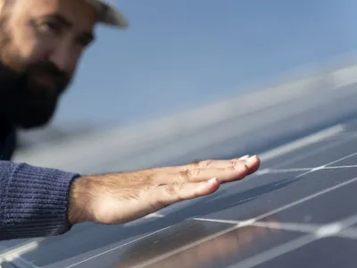 Un bărbat verifică conformitatea unei uzine de energie regenerabilă - Foto: Magnific.com/magnific