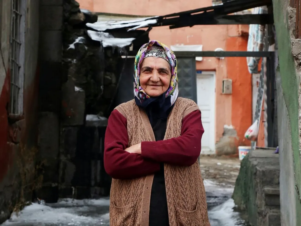 Femeie bătrână pozată în faţa casei sala sărăcăcioase - Foto: Pexels/Şahin Sezer Dinçer (Imagine cu caracter ilustrativ)