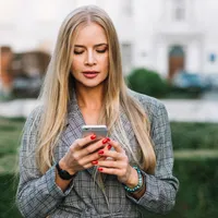 O femeie citește mesaje pe telefon - Foto: Freepik (rol ilustrativ)