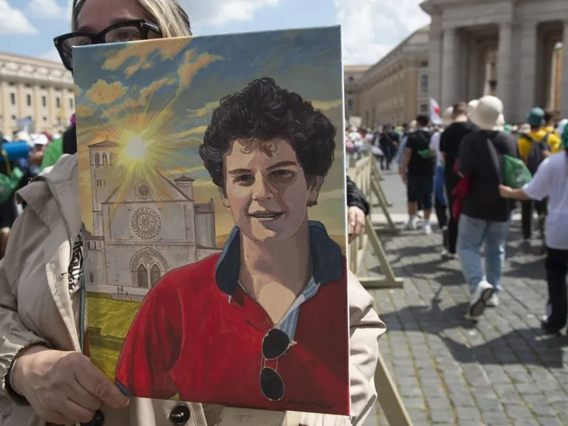 Fotografie cu Carlo Acutis, a cărui canonizare a fost amânată, în timp ce tinerii se adună pentru o liturghie pentru regretatul Papă Francisc, În Piaţa Sf. Petru, la Vatican - Foto: Profimedia Images