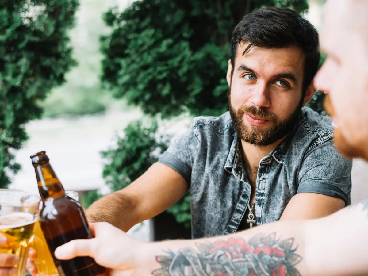 Bărbați care ciocnesc sticlele cu alcool - Foto: Freepik (imagine cu rol ilustrativ)