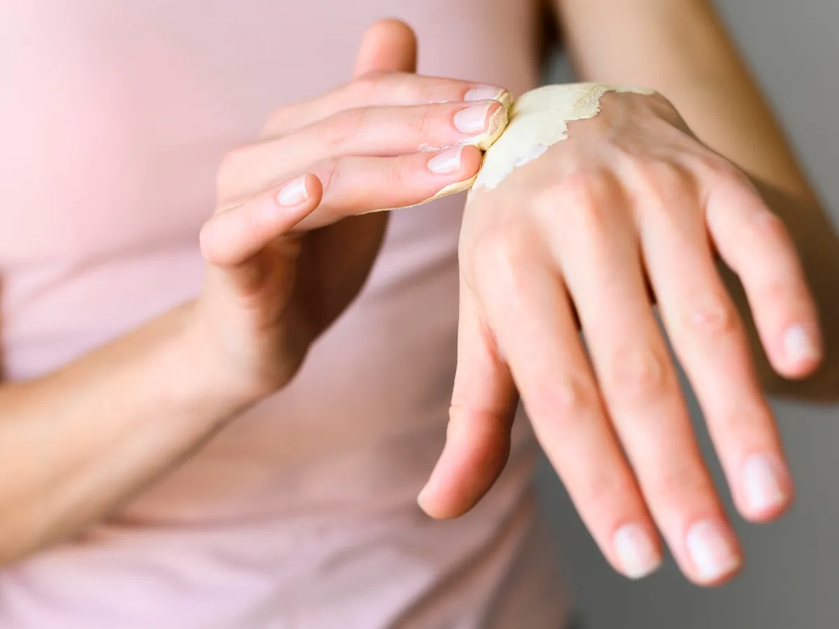 Persoană care se dă cu cremă - Foto: Freepik (Imagine cu rol ilustrativ)