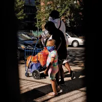 DUREREA FOAMEI O femeie și doi copii părăsesc o bancă de alimente din Brooklyn, New York. TEB-ul de vară va oferi familiilor cu venituri mici 120 de dolari de copil pentru cumpărături