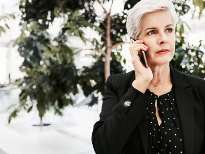 Pensionară la pensie vorbește la mobil - Foto: Freepik