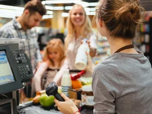 Angajată la supermarket scanează produse - Foto: Freepik