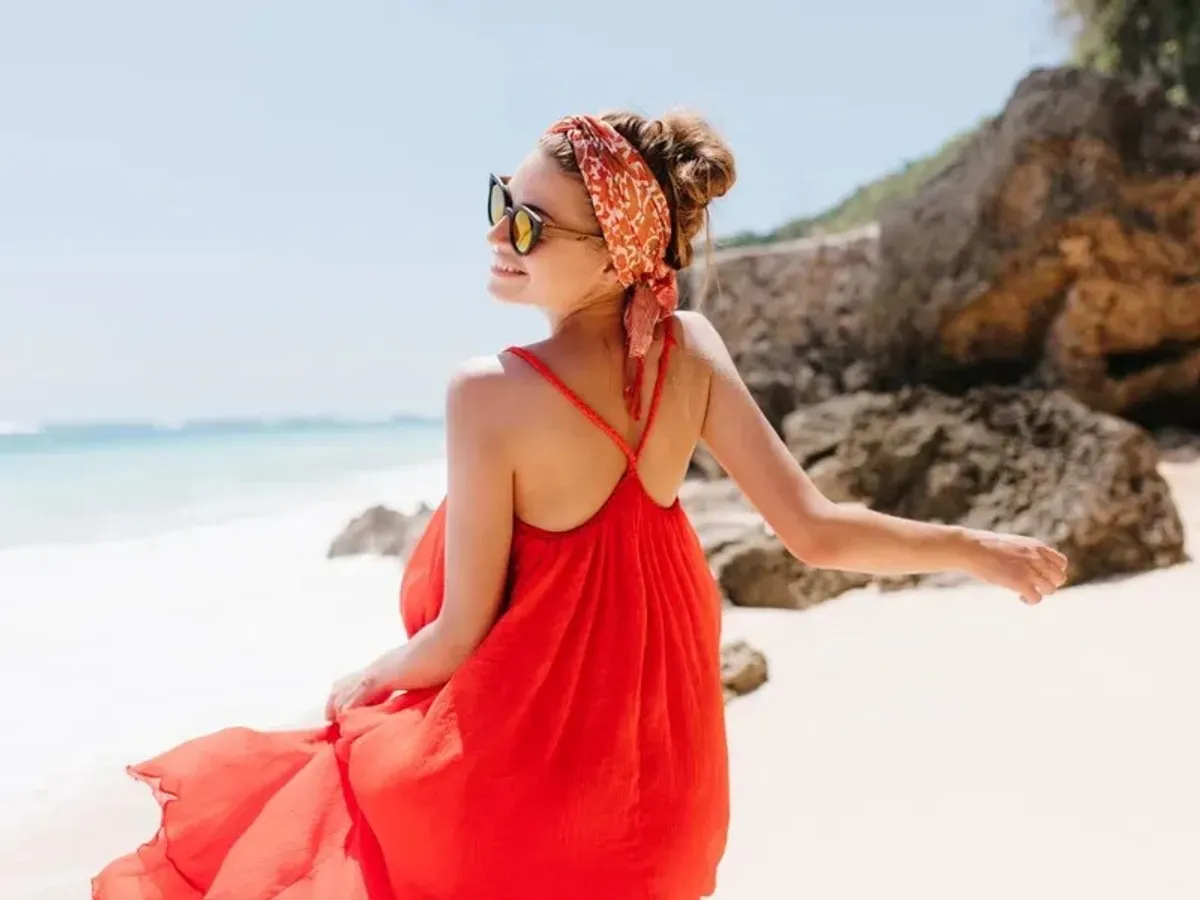 Turistă la plajă - Foto: Freepik/lookstudio