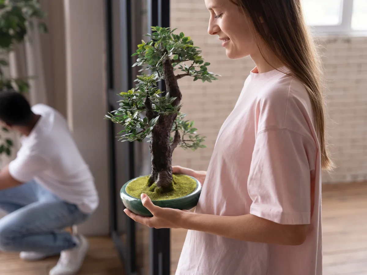 Femeie care ține o plantă Feng Shui - Foto: Freepik (Imagine cu rol ilustrativ)