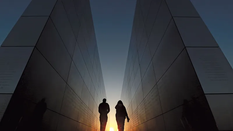 Oamenii merg prin Memorialul Cerului Gol 9/11 din Liberty State Park, New Jersey