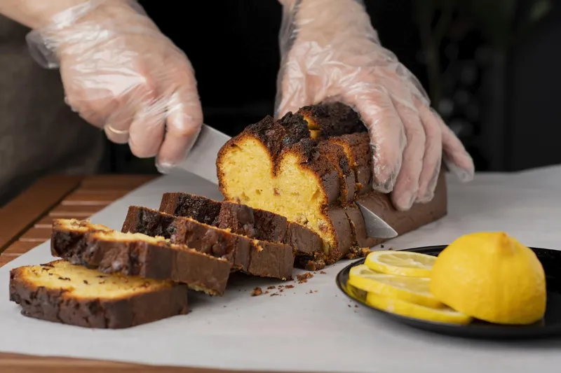 Persoană care taie un cozonac - Foto: Freepik (Imagine cu rol ilustrativ)