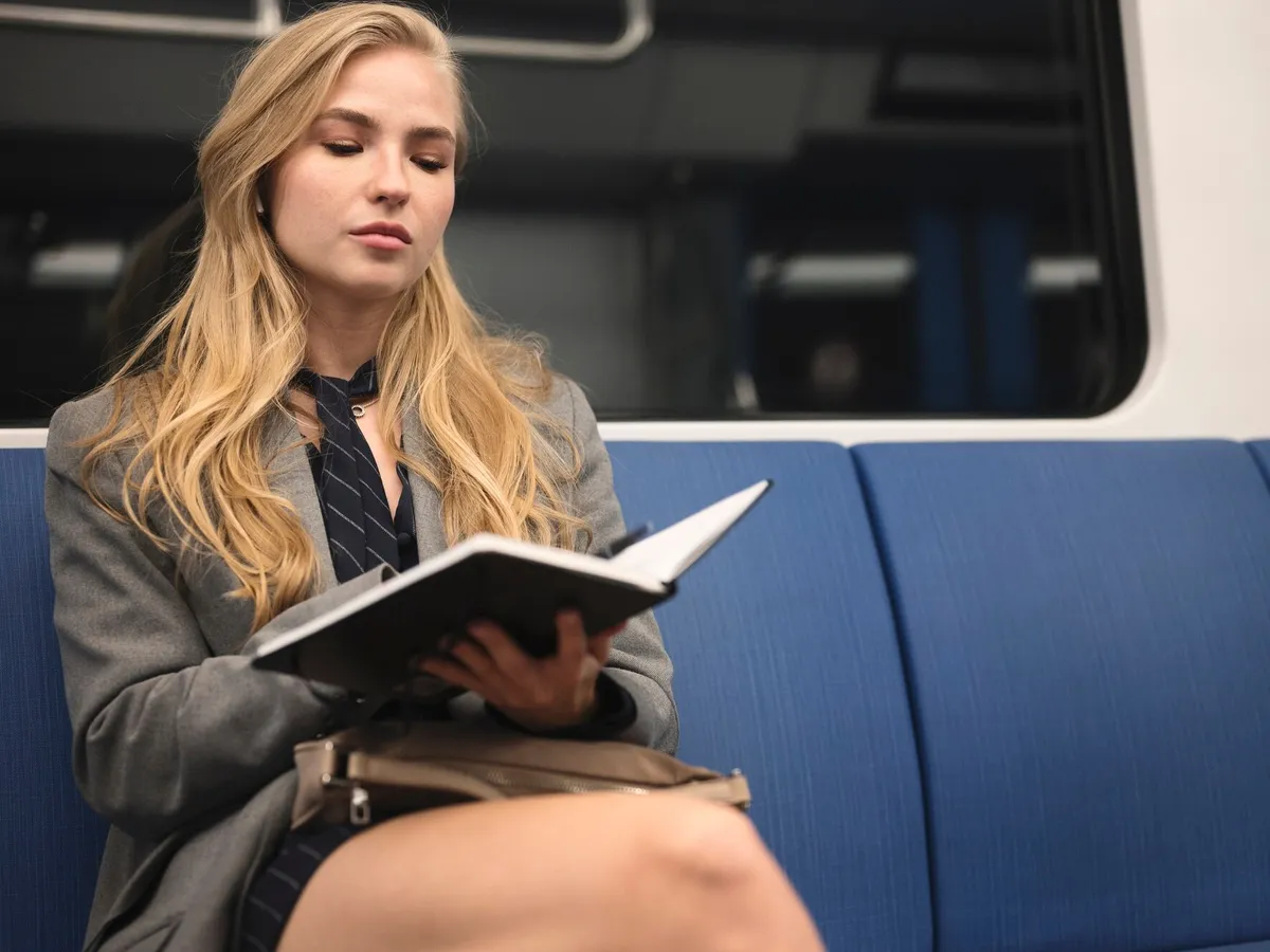Fată frumoasă care citește în tren - Foto: Freepik (imagine cu rol ilustrativ)