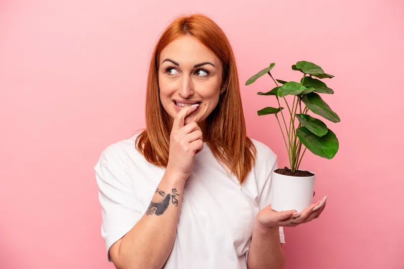 Femeie cu o plantă &icirc;n m&acirc;nă - Foto: Freepik (Imagine cu rol ilustrativ)