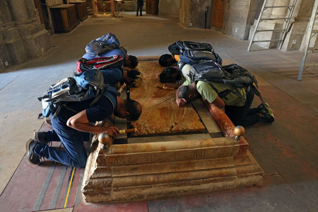 Şase pelerini, la Piatra de ungere, unde se presupune că a fost depus Iisus, după coborîrea de pe Cruce - Foto: Profimedia Images