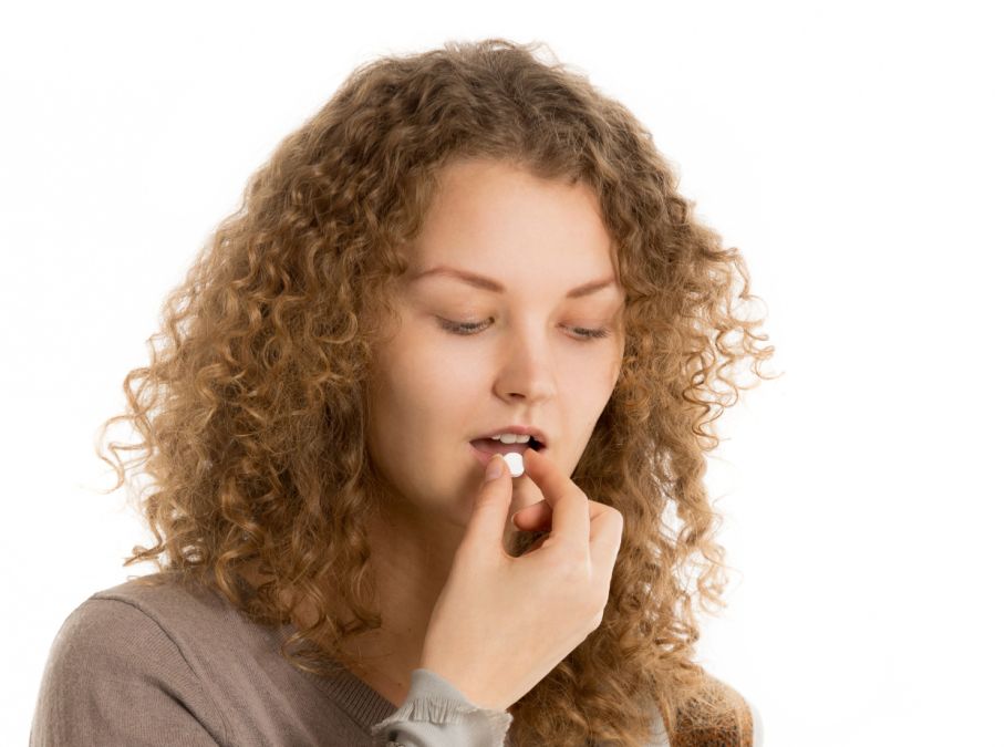 Tânără femei luându-şi medicamentele compensate - Foto: Freepik/yanalya